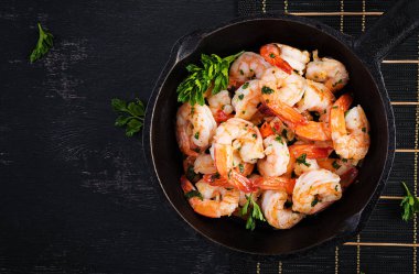 Kızarmış karides. Limon, maydanoz ve sarımsaklı tavada kızarmış karides. Üst görünüm, genel görünüm