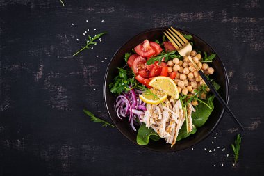 Tavuk fileto, nohut, domates, kırmızı soğan, taze yeşil salata ve susam tohumlu Buda kasesi. Sağlıklı dengeli beslenme. Üst görünüm, yukarıda, boşluğu kopyala