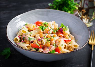 Vejetaryen sebze makarnası. Domatesli makarna, kırmızı soğan, maydanoz ve fındık soslu kızarmış nohut. Vejetaryen yemeği.