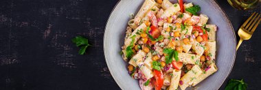 Vejetaryen sebze makarnası. Domatesli makarna, kırmızı soğan, maydanoz ve fındık soslu kızarmış nohut. Vejetaryen yemeği. Üst görünüm, afiş