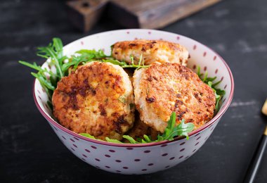 Sağlıklı bir akşam yemeği. Koyu arkaplanda bir kasede tavuk pirzolası.