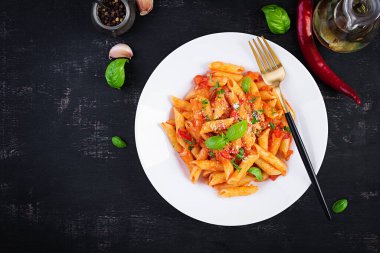 Klasik İtalyan usulü makarna penne alla arrabiata fesleğen ve taze rendelenmiş parmesan peyniri. Acı soslu arrabbiata soslu makarna. Üst görünüm, yukarıda, boşluğu kopyala