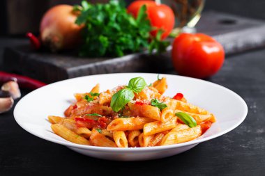 Klasik İtalyan usulü makarna penne alla arrabiata fesleğen ve taze rendelenmiş parmesan peyniri. Acı soslu arrabbiata soslu makarna..