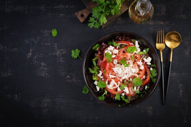 Domatesli sebze salatası, taze marul, yumuşak peynir ve soğan. Sağlıklı diyet yemekleri. Üst görünüm, yukarıda