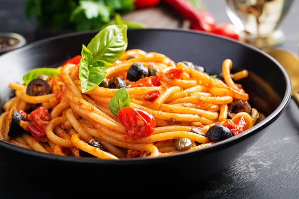 スパゲッティアッラ プッタネスカ トマトとイタリアのパスタ料理 黒オリーブ ケッパー アンチョビとバジル — ストック写真