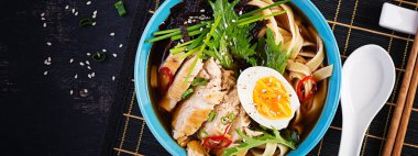 Miso çorbası. Japon ramen çorbası tavuk, yumurta, nori ve nipposinica ile koyu arkaplanda. Üst manzara, düz döşeme, pankart