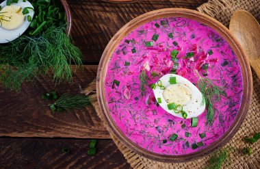 Soğuk borş, taze salatalıklı pancar çorbası, haşlanmış yumurta ve ahşap masada fırında patates. Geleneksel Avrupa yemekleri, lezzetli öğle yemekleri. Üst görünüm, genel görünüm