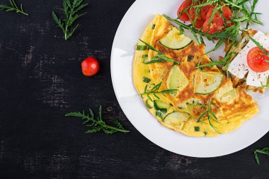 Kabaklı omlet, yeşil otlar ve tabakta peynirli sandviç. Frittata - İtalyan omleti. Üst görünüm, yukarıda, boşluğu kopyala