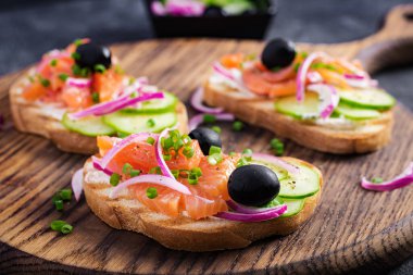 Krem peynirli tost, füme somon, salatalık ve kırmızı soğan. Sandviç aç. Sağlıklı bakım, süper gıda konsepti.