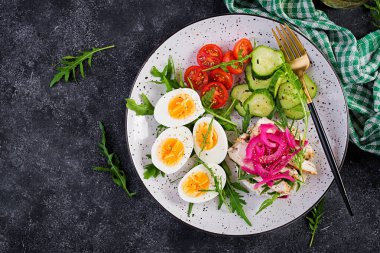 Kahvaltıda. Haşlanmış yumurta salatası, salatalık, salatalık, domates ve ricotta peynirli sandviç, kızarmış tavuk fileto ve kırmızı soğan. Keto / Paleo öğle yemeği. Üst görünüm, genel görünüm