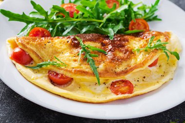 Kahvaltıda. Beyaz tabakta domatesli omlet, peynir ve salata. Frittata - İtalyan omleti.