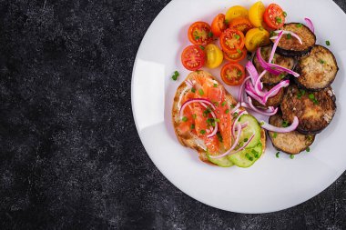 Lezzetli brunch somon ekmekli krem peynirli sandviçler ve roka, koyu arkaplanda domates salatası. Üst görünüm, yukarıda
