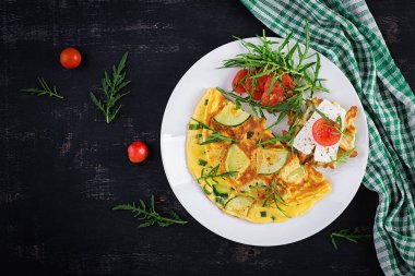 Kabaklı omlet, yeşil otlar ve tabakta peynirli sandviç. Frittata - İtalyan omleti. Üst görünüm, yukarıda, boşluğu kopyala