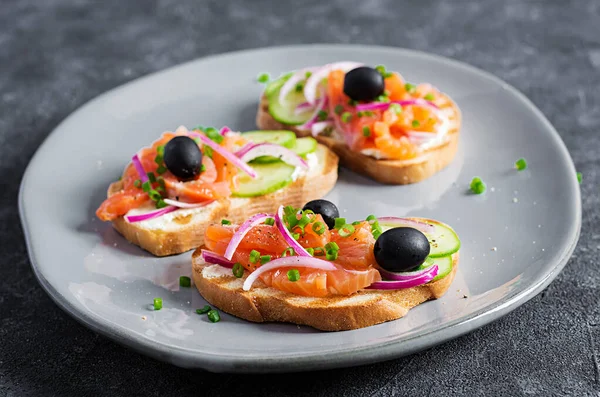 Toasturi Brânză Cremă Somon Afumat Castravete Măsline Negre Ceapă Roșie — Fotografie, imagine de stoc