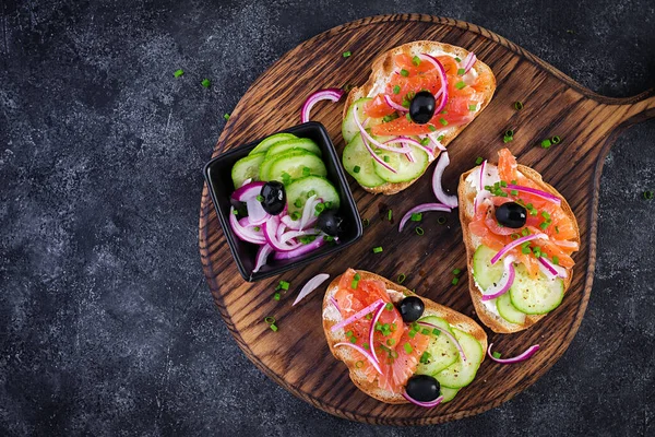 Toasturi Brânză Cremă Somon Afumat Castravete Ceapă Roșie Masa Întunecată — Fotografie, imagine de stoc