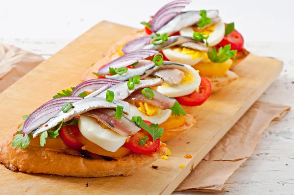 Crostini with anchovies, tomatoes and egg — Stock Photo, Image