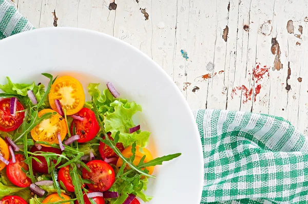 Rajčatový salát s hlávkovým salátem, arugala a cibulí — Stock fotografie