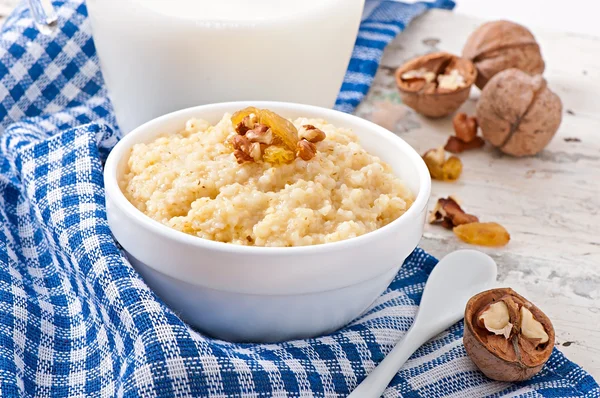 Porridge with nuts, raisins and jar of milk — Stock Photo, Image