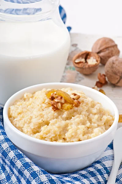 Porridge with nuts, raisins and jar of milk — Stock Photo, Image