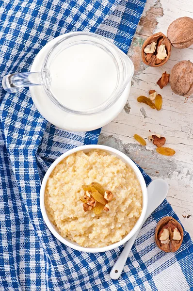 Porridge with nuts, raisins and jar of milk — Stock Photo, Image