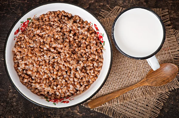 Buchweizen in einer Schüssel und einem Becher Milch — Stockfoto