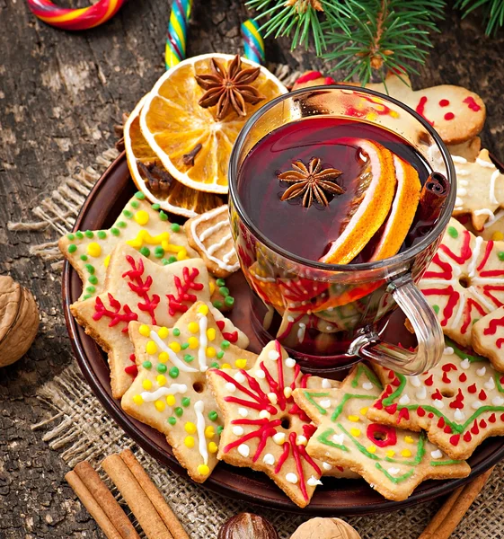 Warming mulled wine, spices and gingerbread cookie on a wooden background in rustic style — Stock Photo, Image