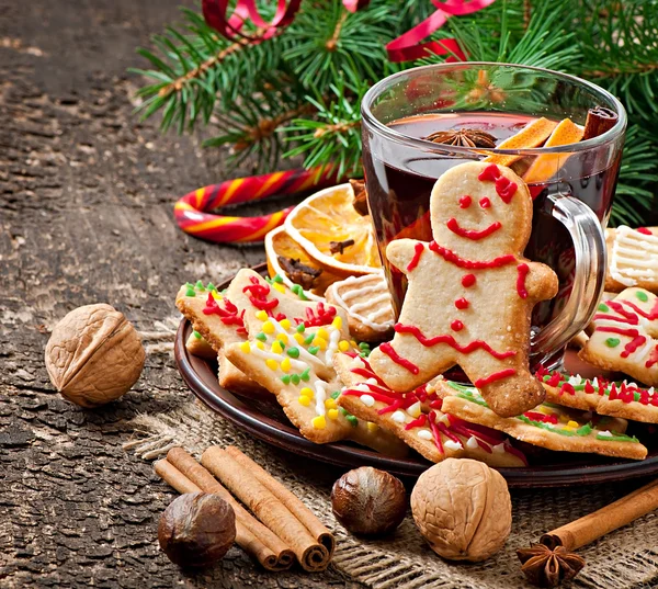 Warming mulled wine, spices and gingerbread cookie on a wooden background in rustic style — Stock Photo, Image