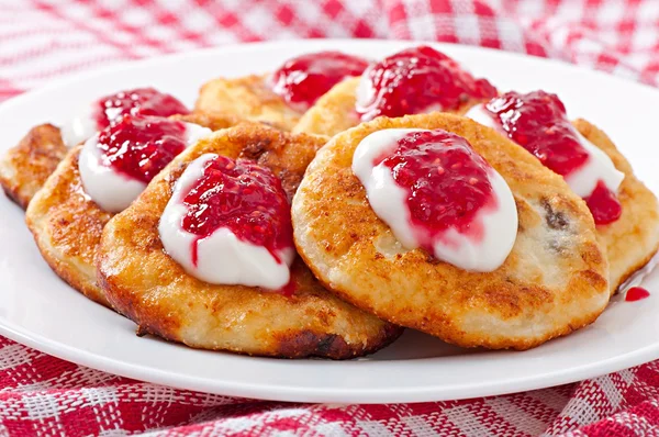 Pancakes of cottage cheese with sour cream and raspberry jam — Stock Photo, Image