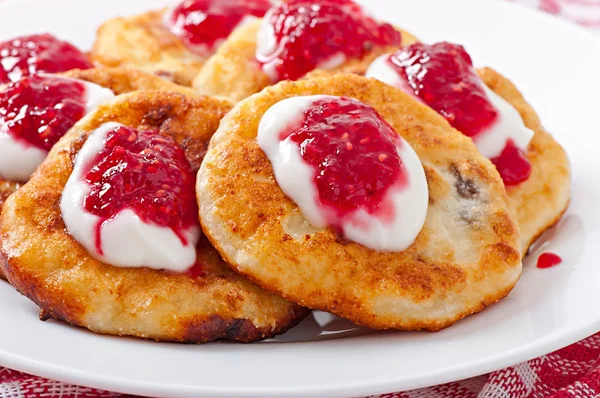 Pancakes of cottage cheese with sour cream and raspberry jam — Stock Photo, Image