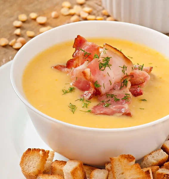 Erbsencremesuppe mit gebratenem Speck und Croutons — Stockfoto