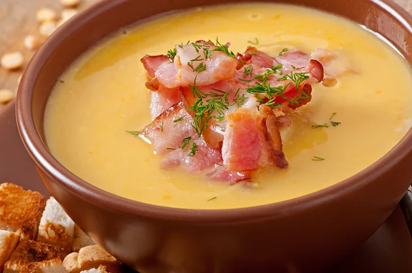 Cream soup of peas with fried bacon and croutons — Stock Photo, Image