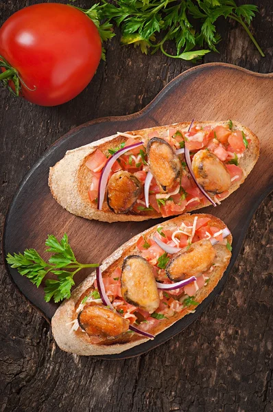 Bruschetta com mexilhões, queijo e tomate — Fotografia de Stock