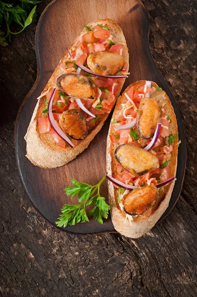 Bruschetta with mussels, cheese and tomatoes — Stock Photo, Image