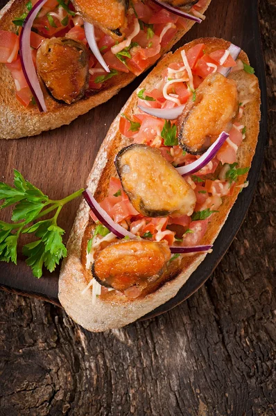 Bruschetta mit Miesmuscheln, Käse und Tomaten — Stockfoto