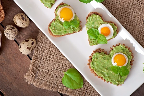 Sandwich with avocado paste and egg in the shape of heart — Stock Photo, Image