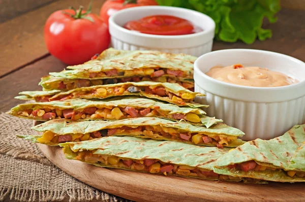 Mexikanska Quesadilla skivad med grönsaker och såser på bordet — Stockfoto