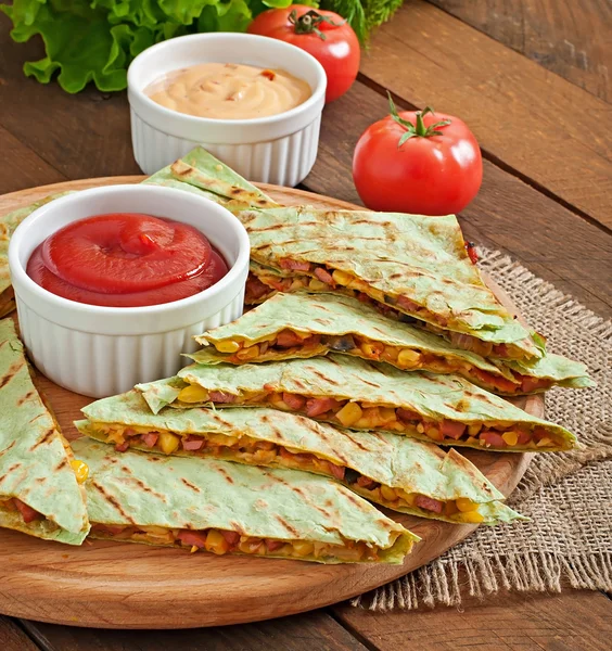 Mexikanska Quesadilla skivad med grönsaker och såser på bordet — Stockfoto