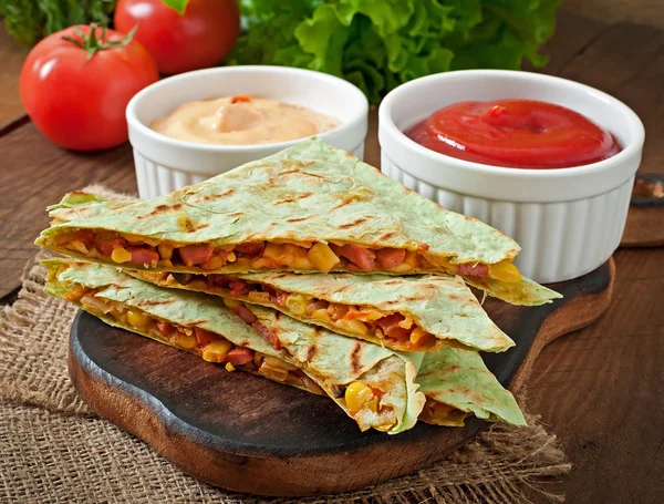 Mexikanska Quesadilla skivad med grönsaker och såser på bordet — Stockfoto