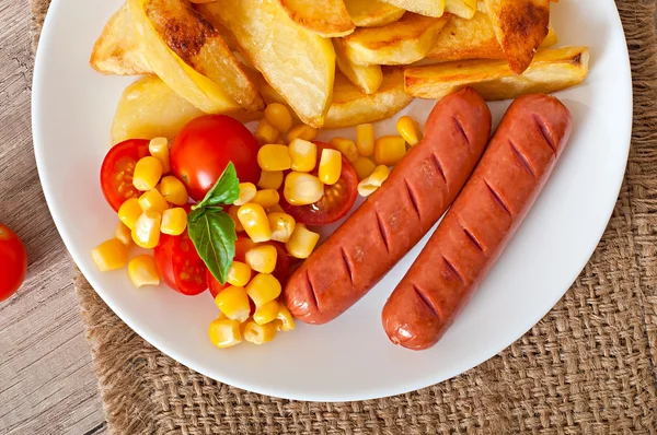 Колбаса с жареной картошкой и овощами — стоковое фото