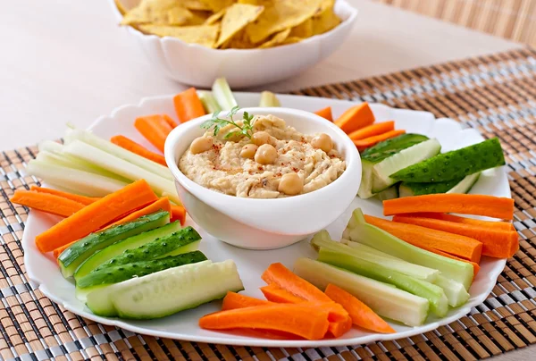 Hummus con verduras, aceite de oliva y papas fritas — Foto de Stock