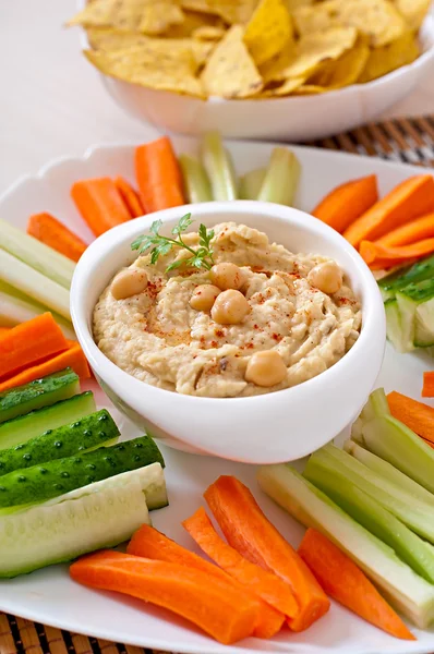 Hummus with vegetables, olive oil and pita chips — Stock Photo, Image