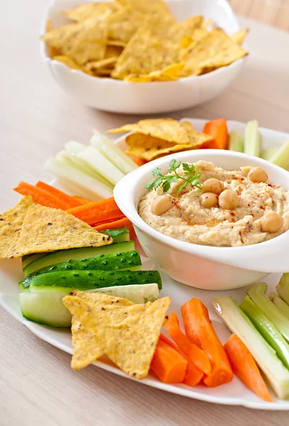 Hummus with vegetables, olive oil and pita chips — Stock Photo, Image