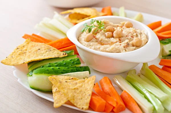 Хумус с овощами, оливковым маслом и чипсами — стоковое фото