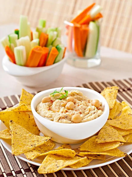 Hummus with vegetables, olive oil and pita chips — Stock Photo, Image