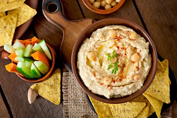 Hummus with vegetables, olive oil and pita chips — Stock Photo, Image