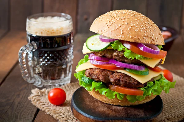Великий бургер з м'ясом, овочами та пивом — стокове фото