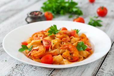 Fettuccine makarna karides, domates ve otlar ile.