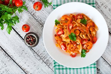 Fettuccine makarna karides, domates ve otlar ile.