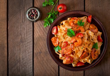 Fettuccine makarna karides, domates ve otlar ile.