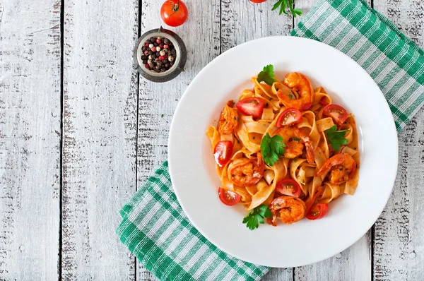 Fettuccine pasta med räkor, tomater och örter. — Stockfoto